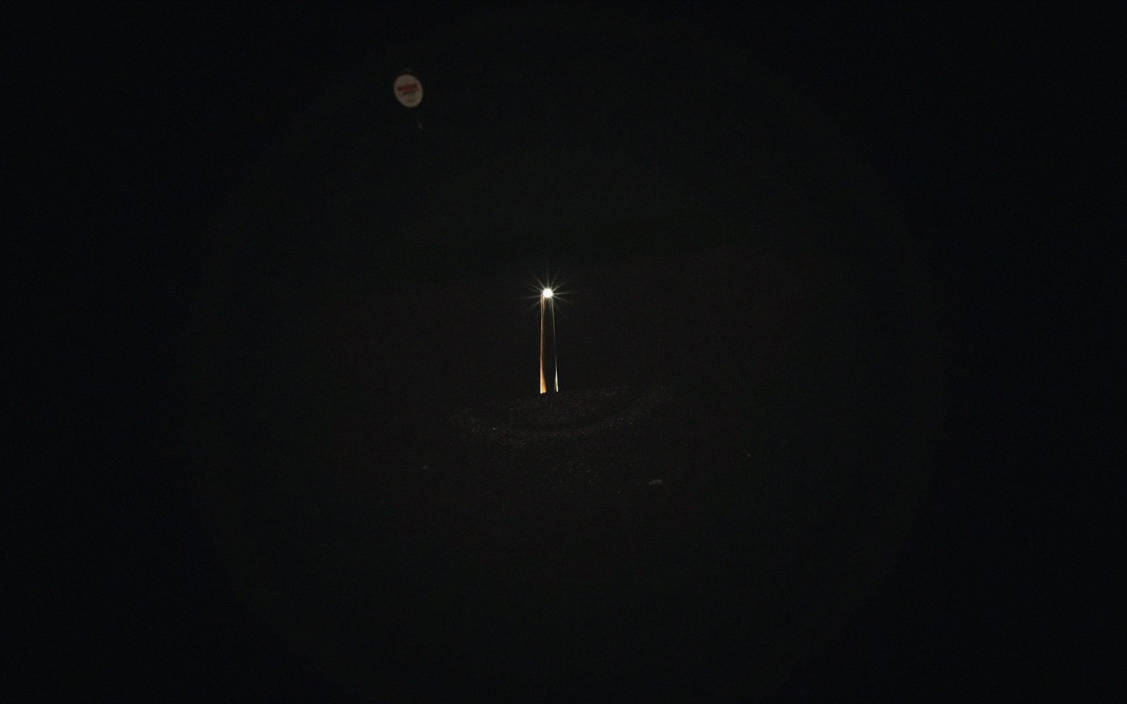 Hard-lit guitar headstock against a black background